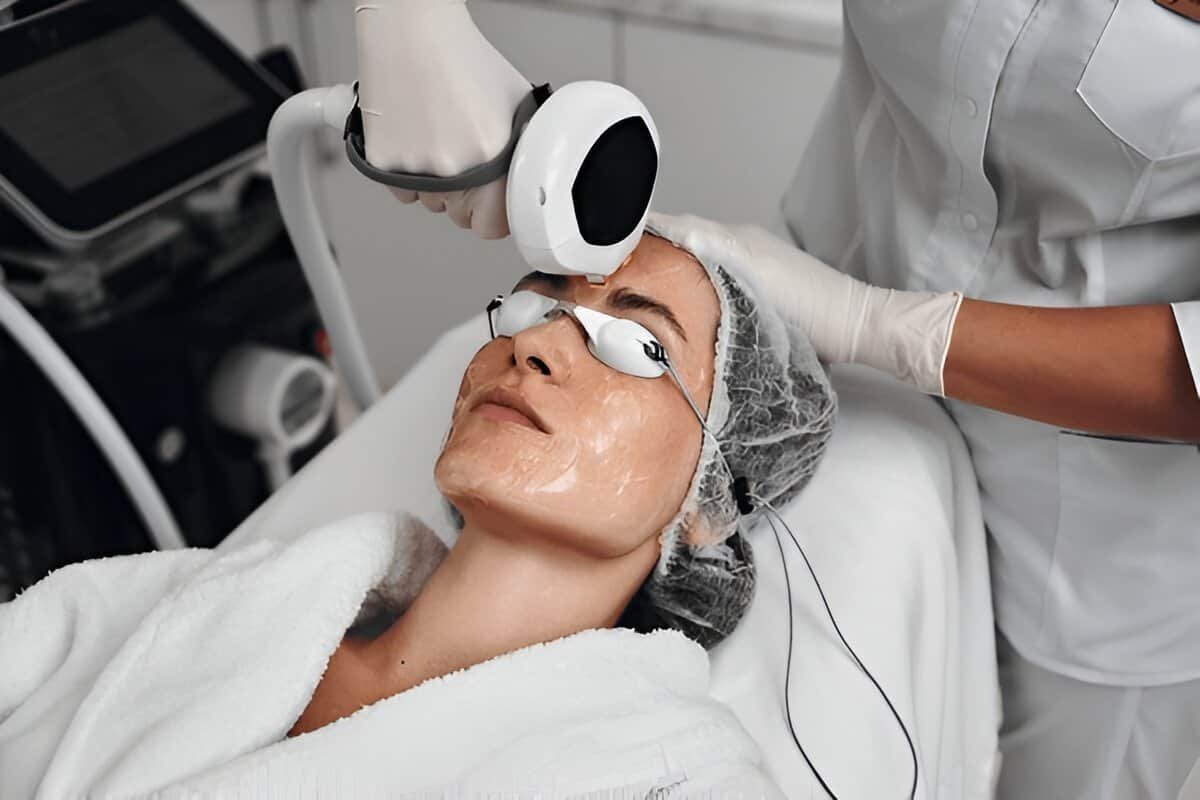 Woman receiving skin rejuvenation treatment with advanced laser technology at Sasha Aesthetic Clinic.