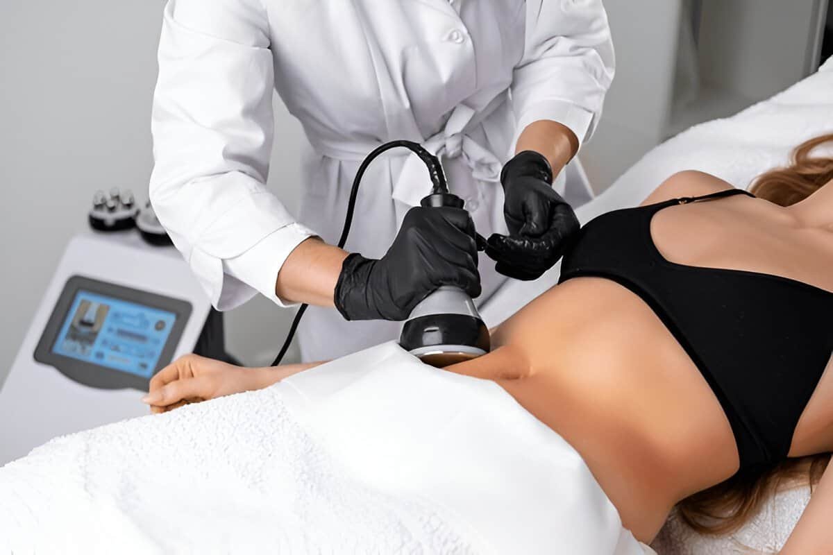 A woman receiving non-invasive body sculpting with a professional technician using a specialized dev.