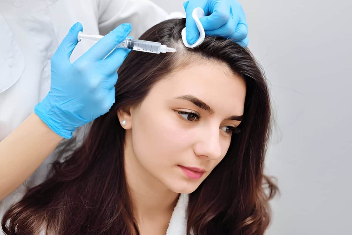 Woman receiving a cosmetic injection by a professional in a clinic setting.